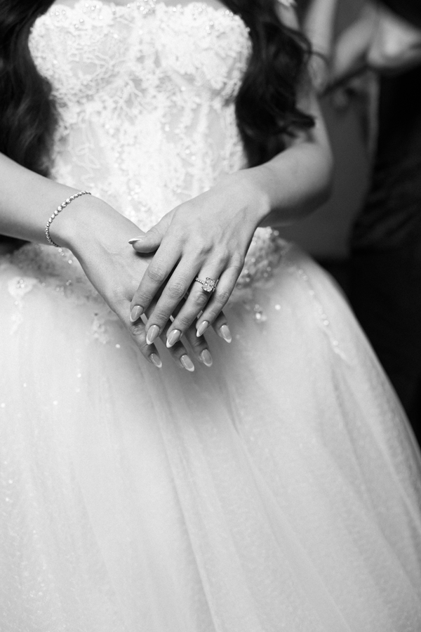 Close-up of the bride's hands and ring against her wedding gown at Villa Pizzo.