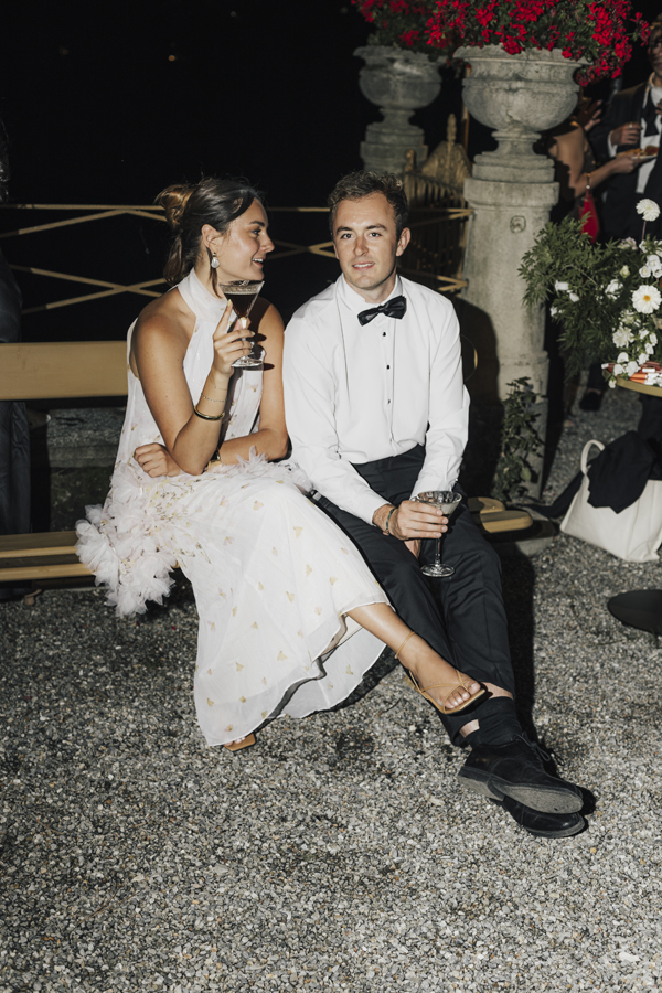 The couple sit together outdoors at Villa Pizzo after dark.
