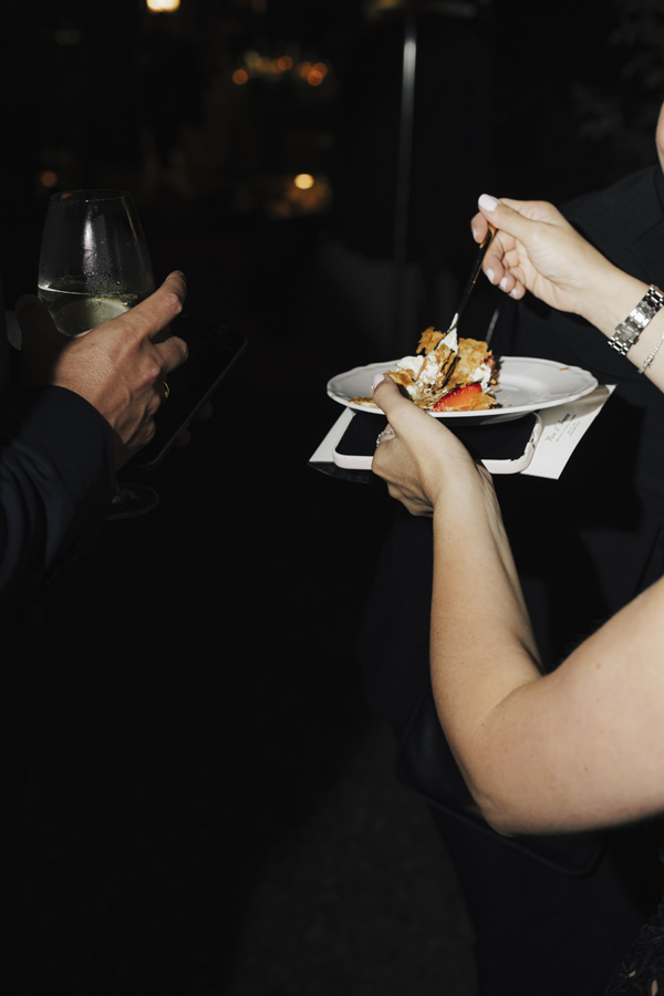 Guests hold plates of late-night food during the party at Villa Pizzo.