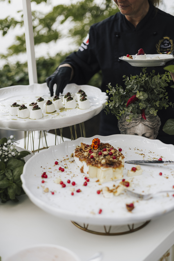 A server prepares small plates of food during the garden aperitivo at Villa Regina Teodolinda.