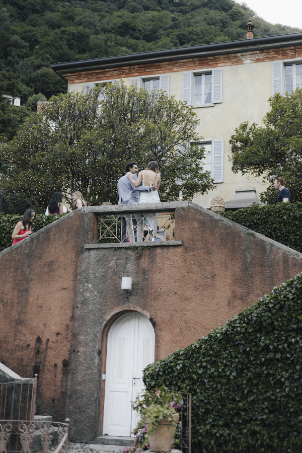 The couple stand together on a small bridge in the garden at Villa Regina Teodolinda.