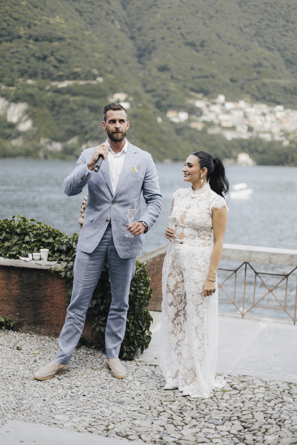 The couple stand together beside Lake Como at Villa Regina Teodolinda.