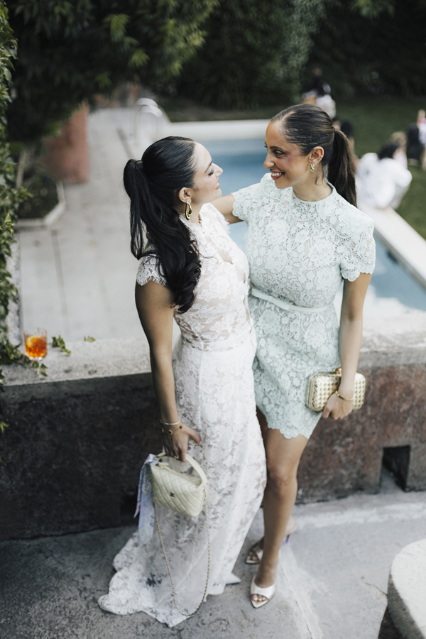 Two women walk together beside Lake Como during the celebration at Villa Regina Teodolinda.