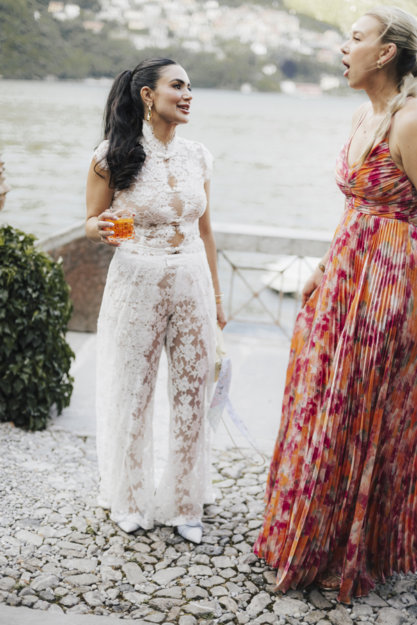Two women chat beside the water during the summer celebration at Villa Regina Teodolinda.