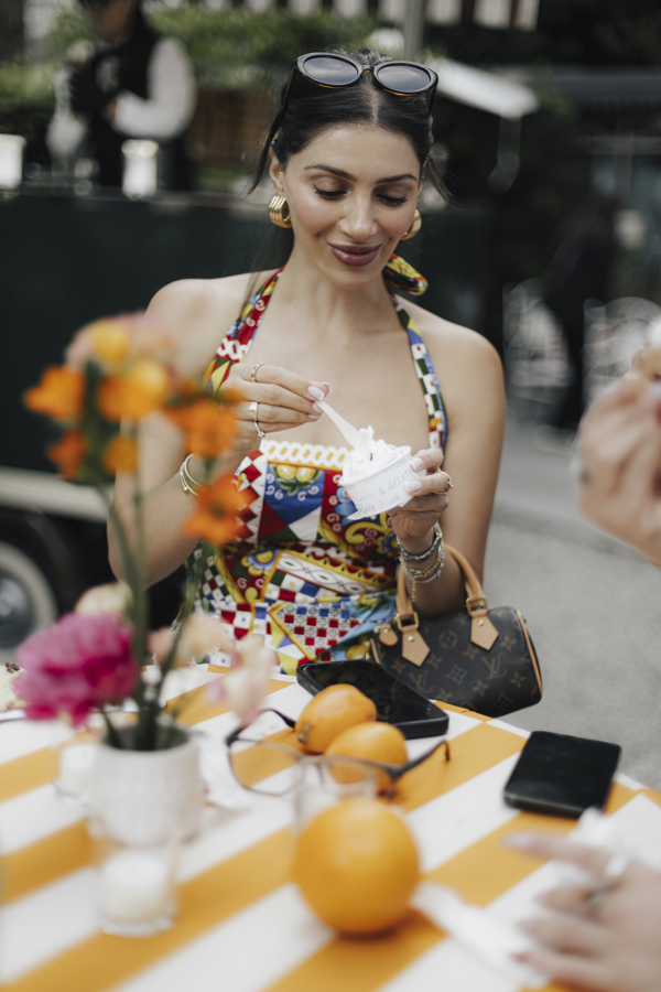 A guest tastes food at an orange-striped table during the aperitivo.