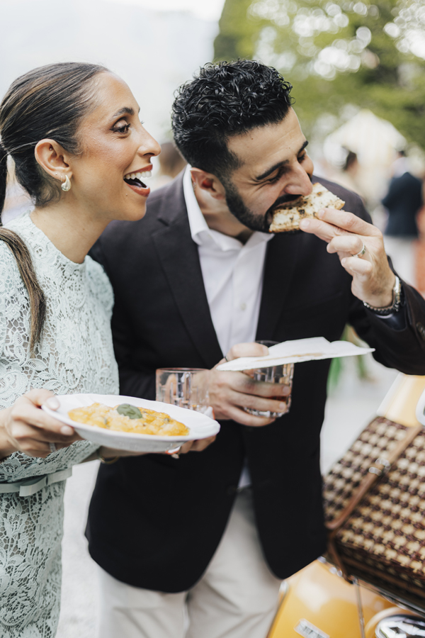 Two guests enjoy food together during the lakeside celebration at Villa Regina Teodolinda.