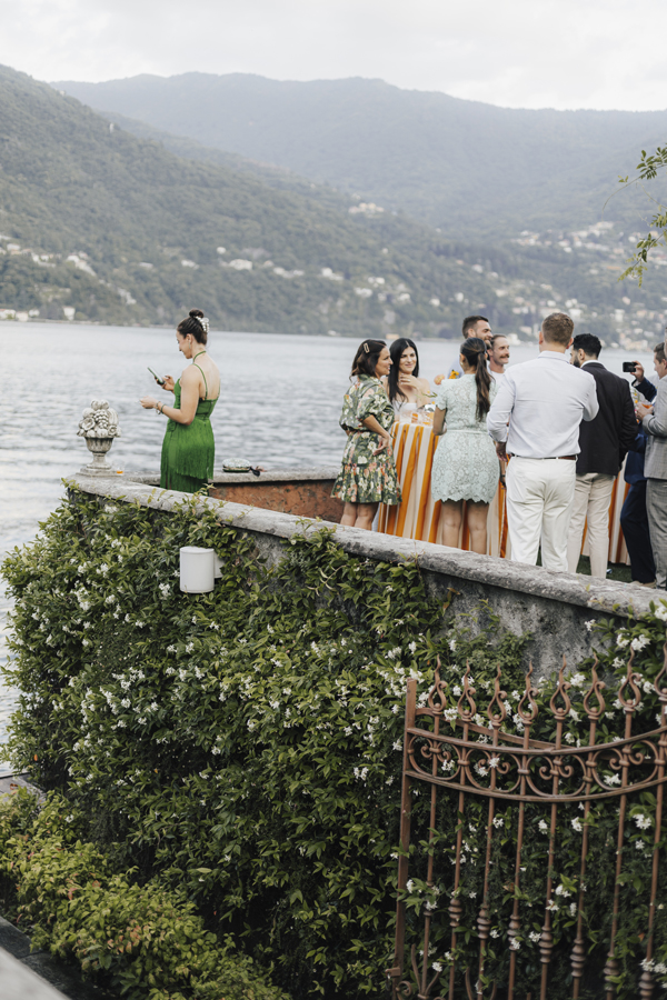 Guests gather along the lakeside terrace with the mountains across Lake Como.