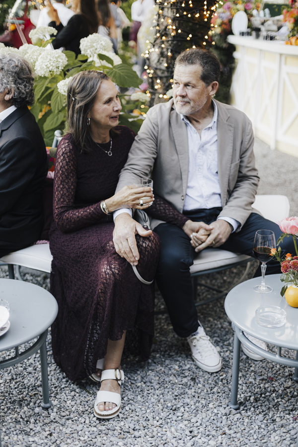 Two guests sit together during the summer celebration at Villa Regina Teodolinda.