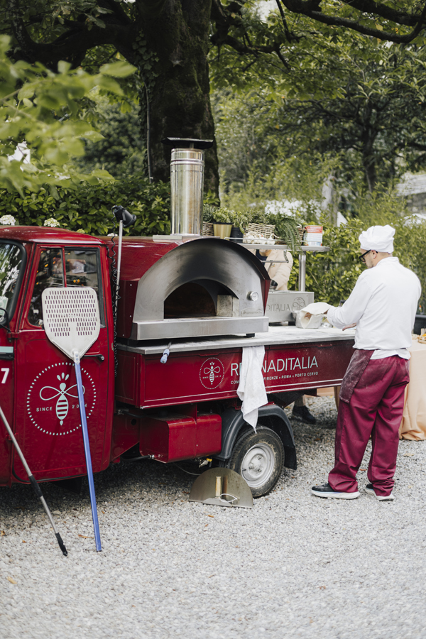 A red mobile pizza oven and chef at the Villa Regina Teodolinda celebration.