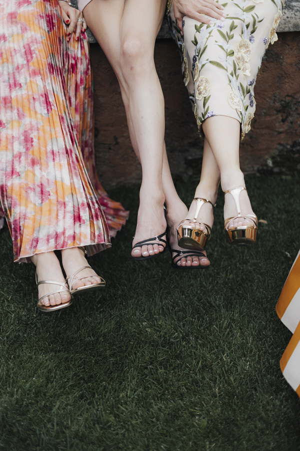 Close-up of three guests' summer dresses and sandals in the garden at Villa Regina Teodolinda.