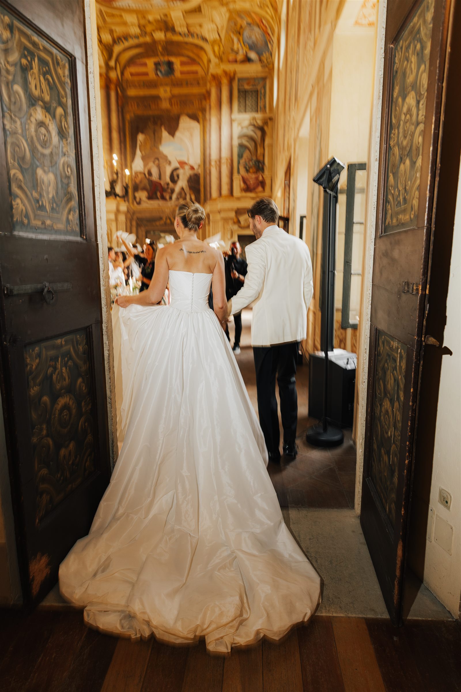 Newlyweds entering the frescoed rooms of Villa Arvedi