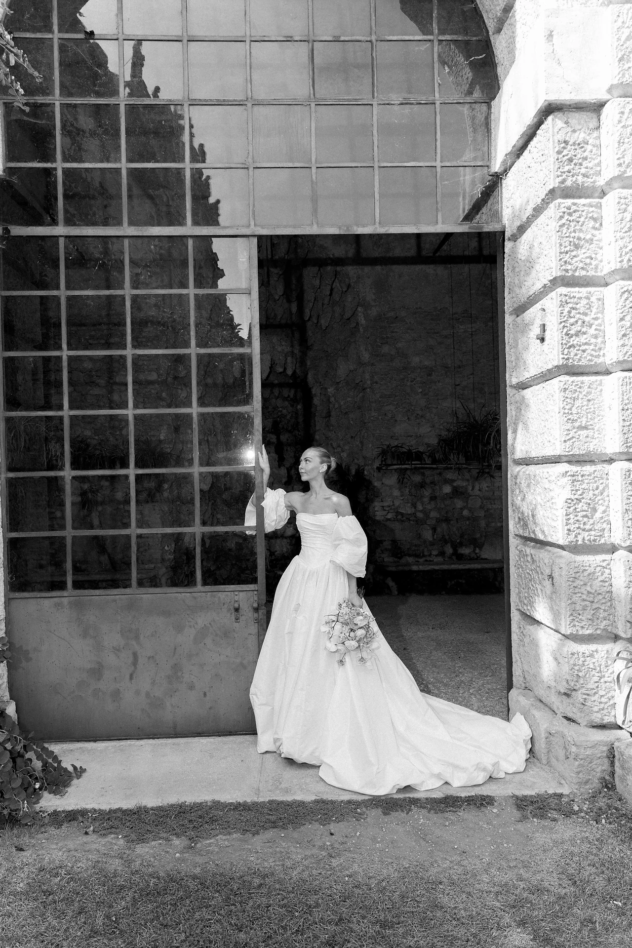 Bride framed by a monumental glass doorway at Villa Arvedi