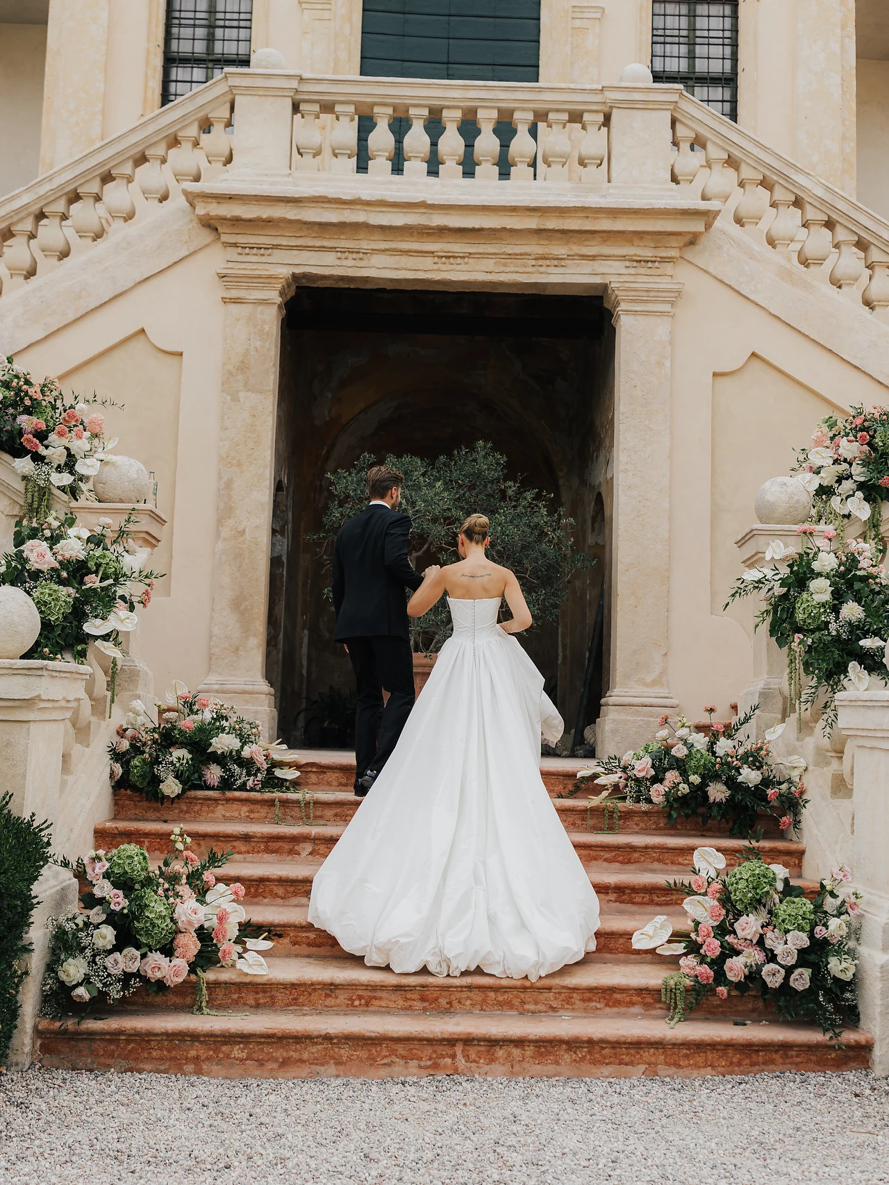 The bride framed by flowers at the grand entrance