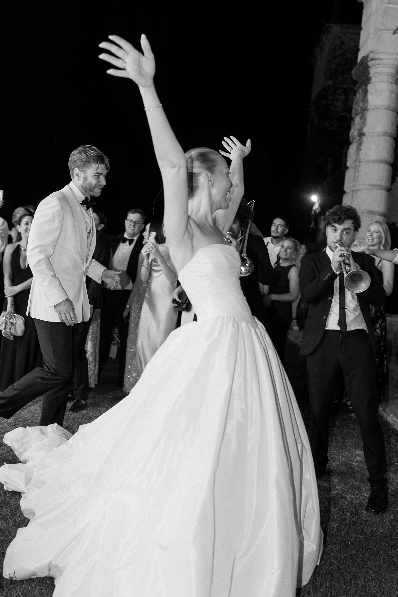 The bride throwing her arms into the air on the dance floor
