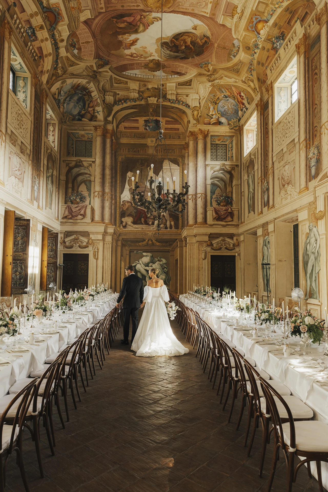 The newlyweds alone between the long dinner tables