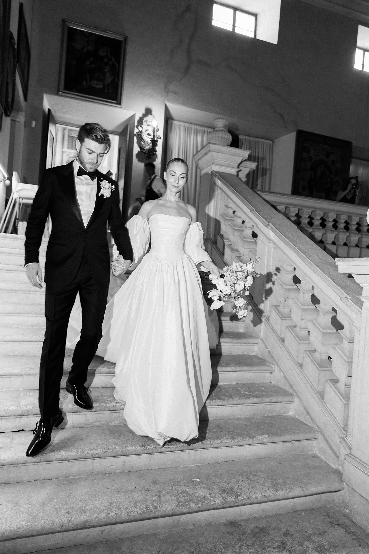 The couple descending the historic staircase