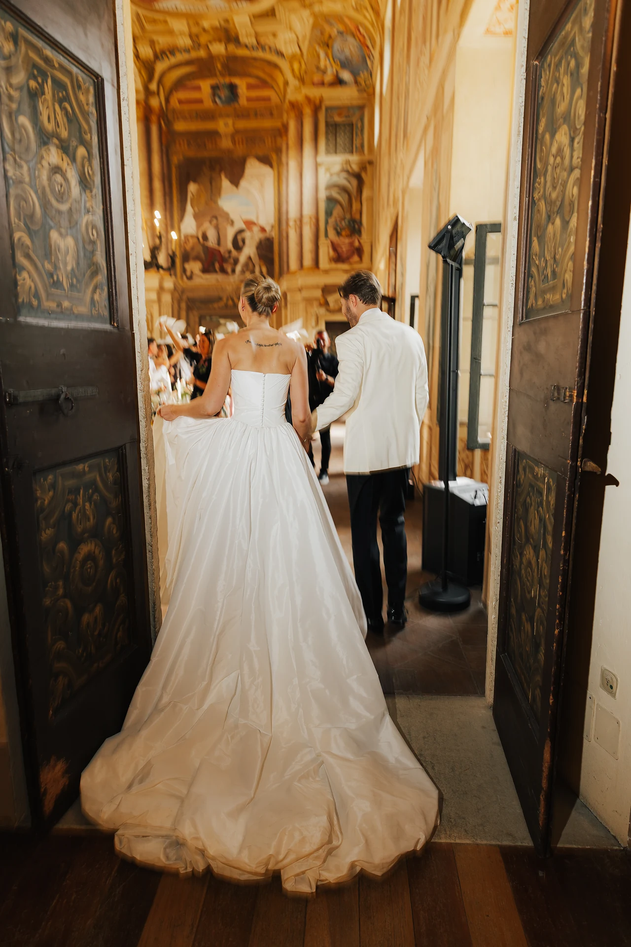 The newlyweds entering the frescoed dinner hall