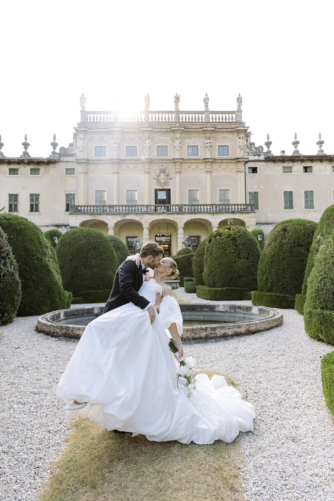 The couple moving through the sculpted garden