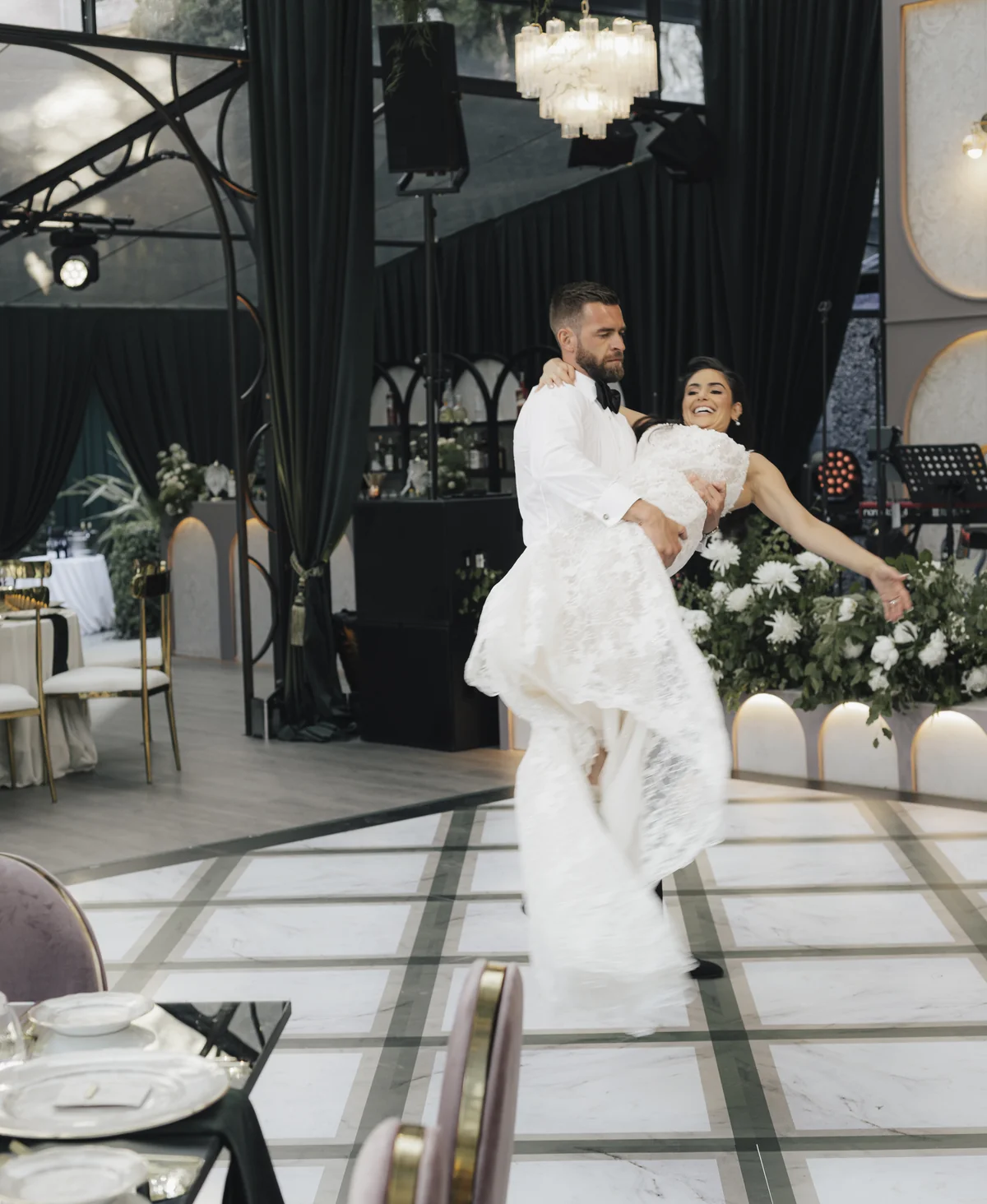 A groom lifts the bride during the Villa Pizzo celebration