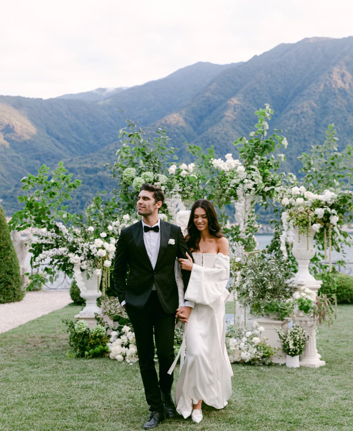 Newlyweds walking through a flower-filled Lake Como garden