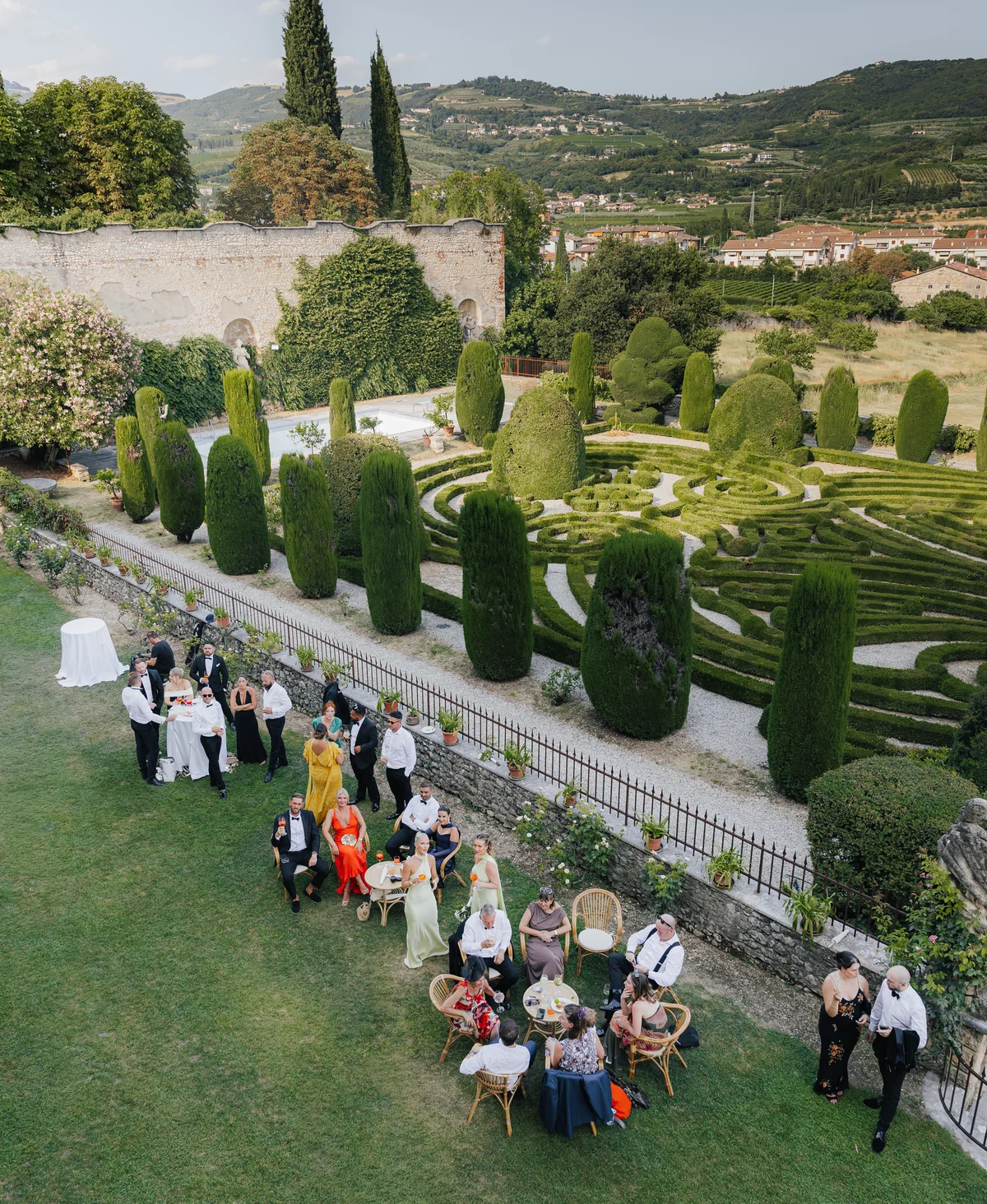 Wedding guests gathering beside the formal gardens at Villa Arvedi