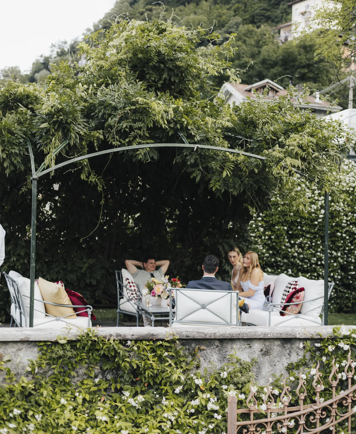 Guests relaxing beneath a leafy garden arch at Villa Pizzo