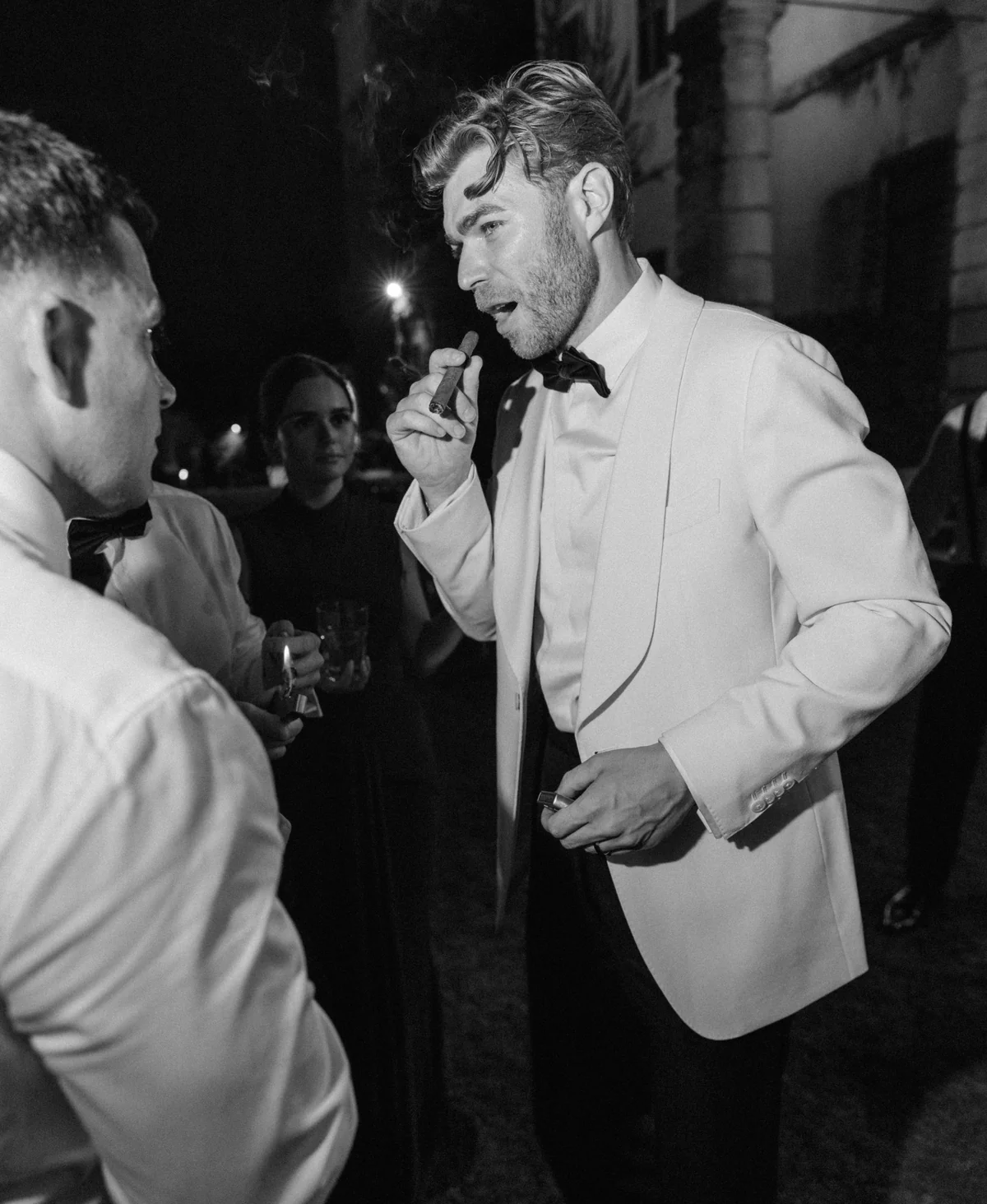 A groom shares a late-night moment with guests at Villa Arvedi