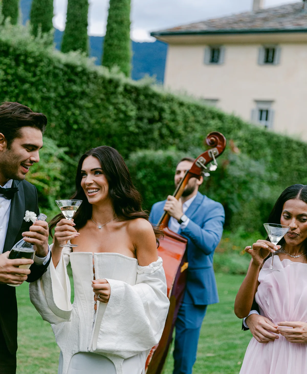 Bride and guests enjoying drinks beside a live jazz musician