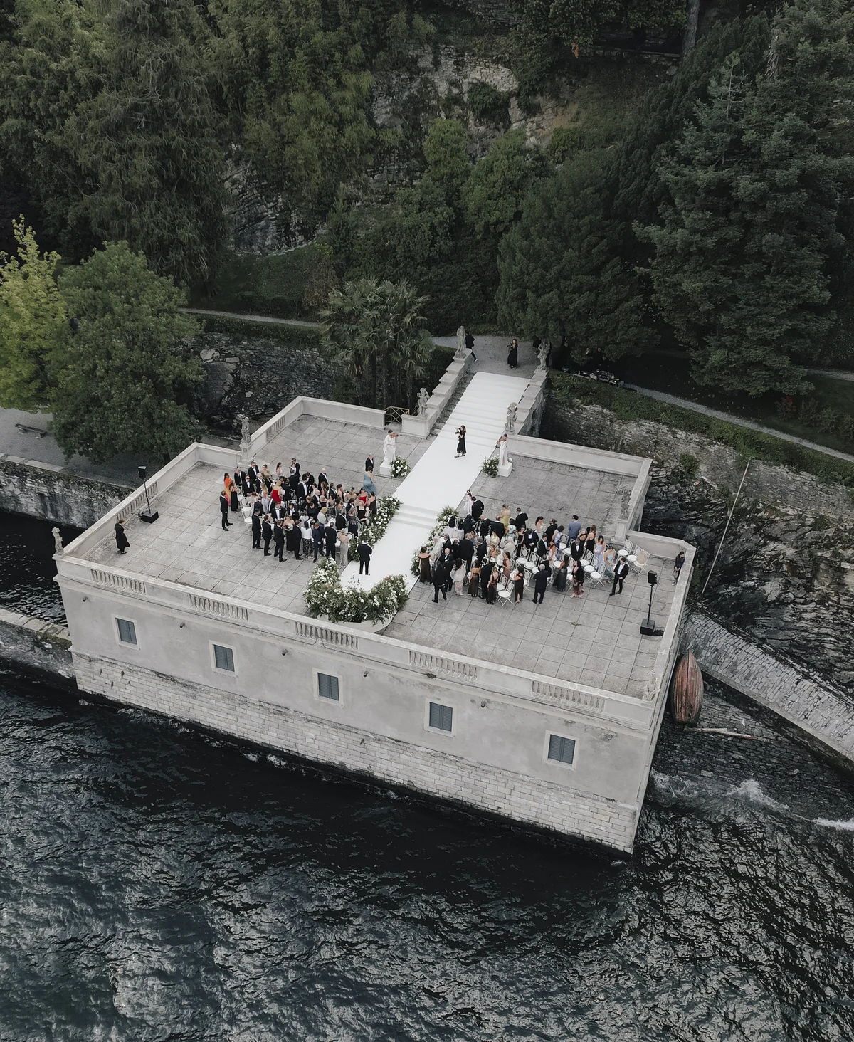 Aerial view of wedding guests gathering on a private lakeside terrace