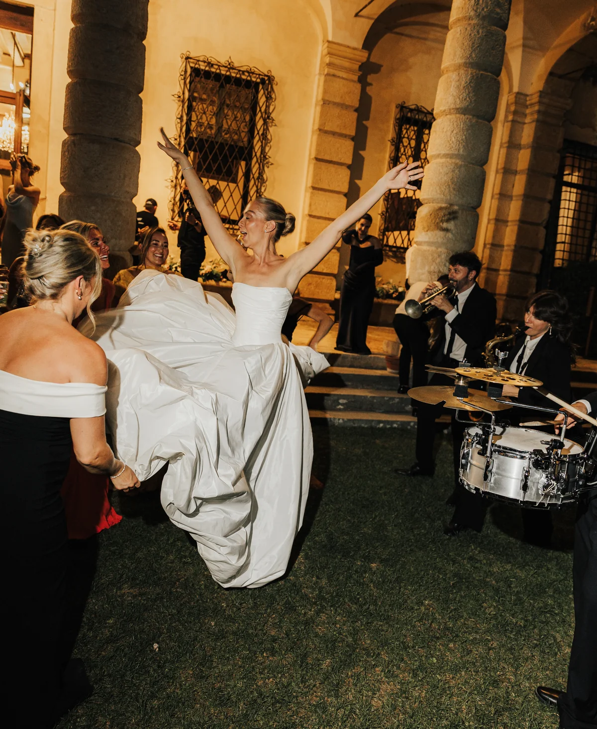 Bride dancing with live musicians at an evening celebration