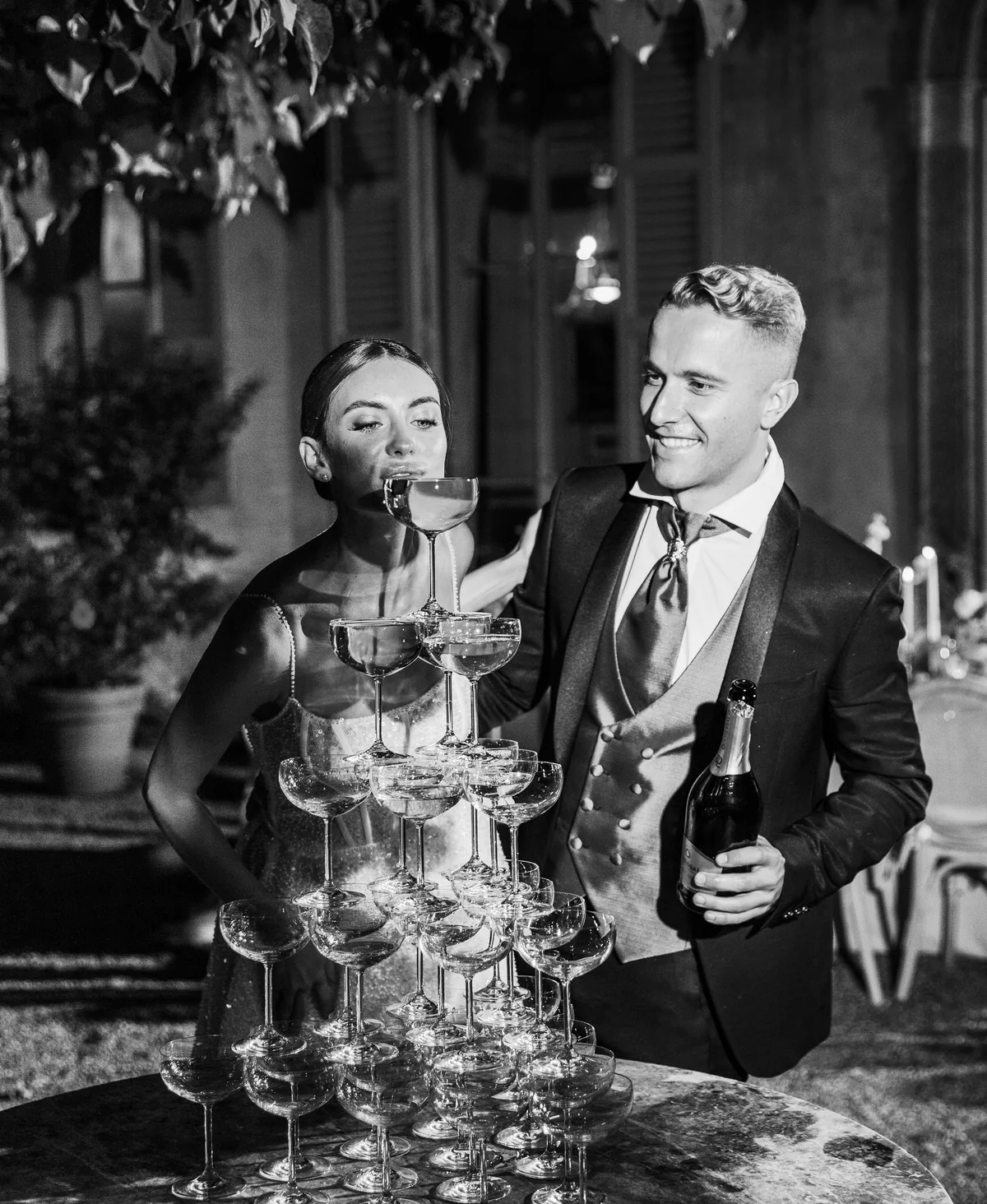 Couple pouring champagne into a tower of glasses