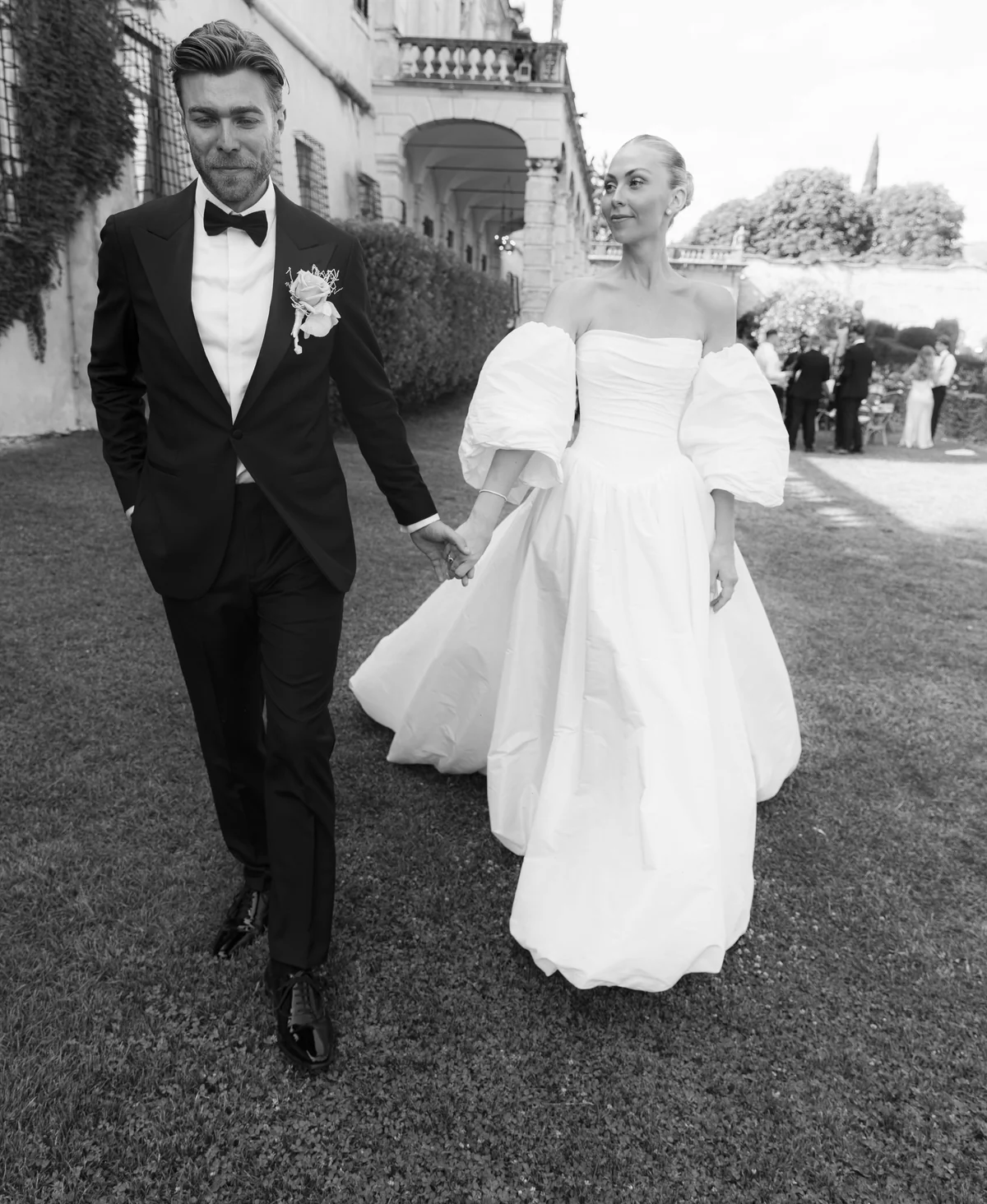 Newlyweds walking together outside an Italian villa in black and white