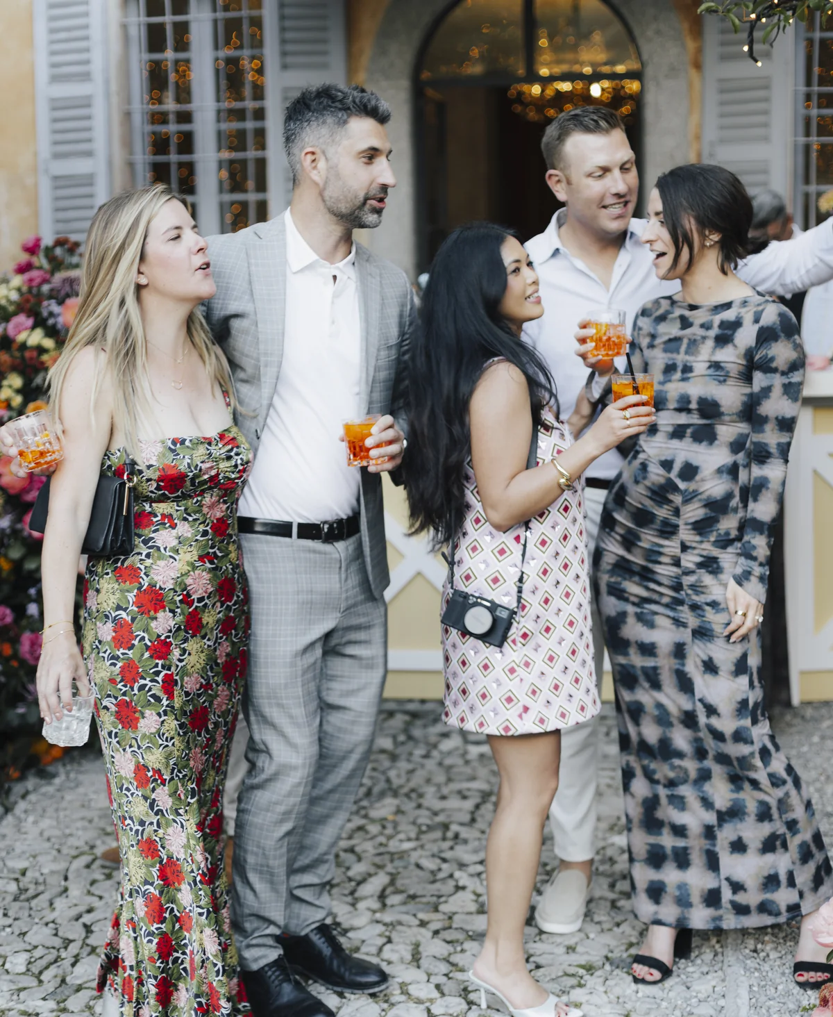 Well-dressed wedding guests chatting over cocktails