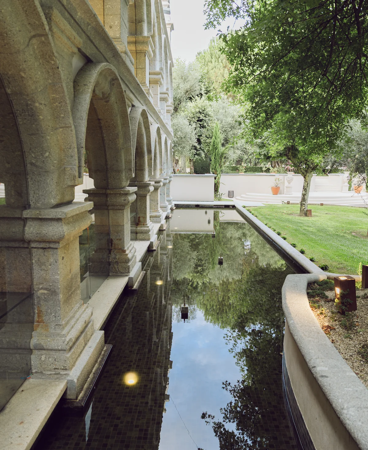 Historic stone arcade and reflecting pool at Solar da Levada