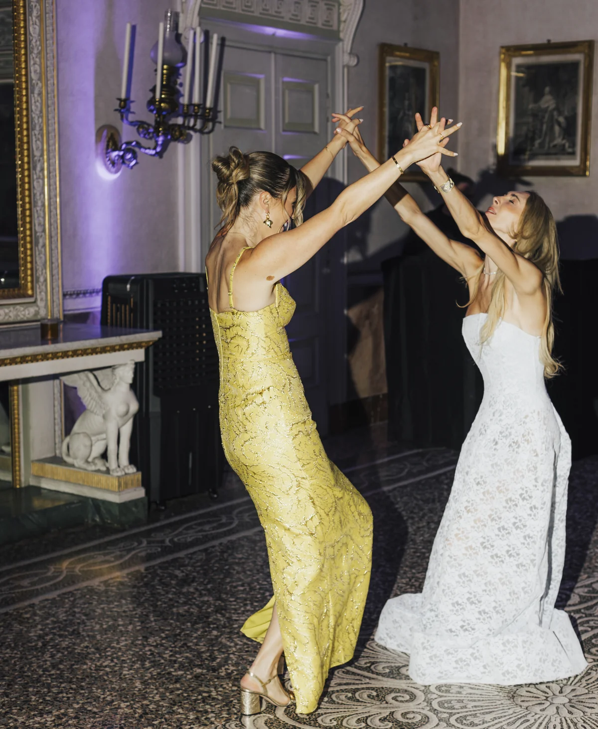 Wedding guests dancing together inside a grand villa