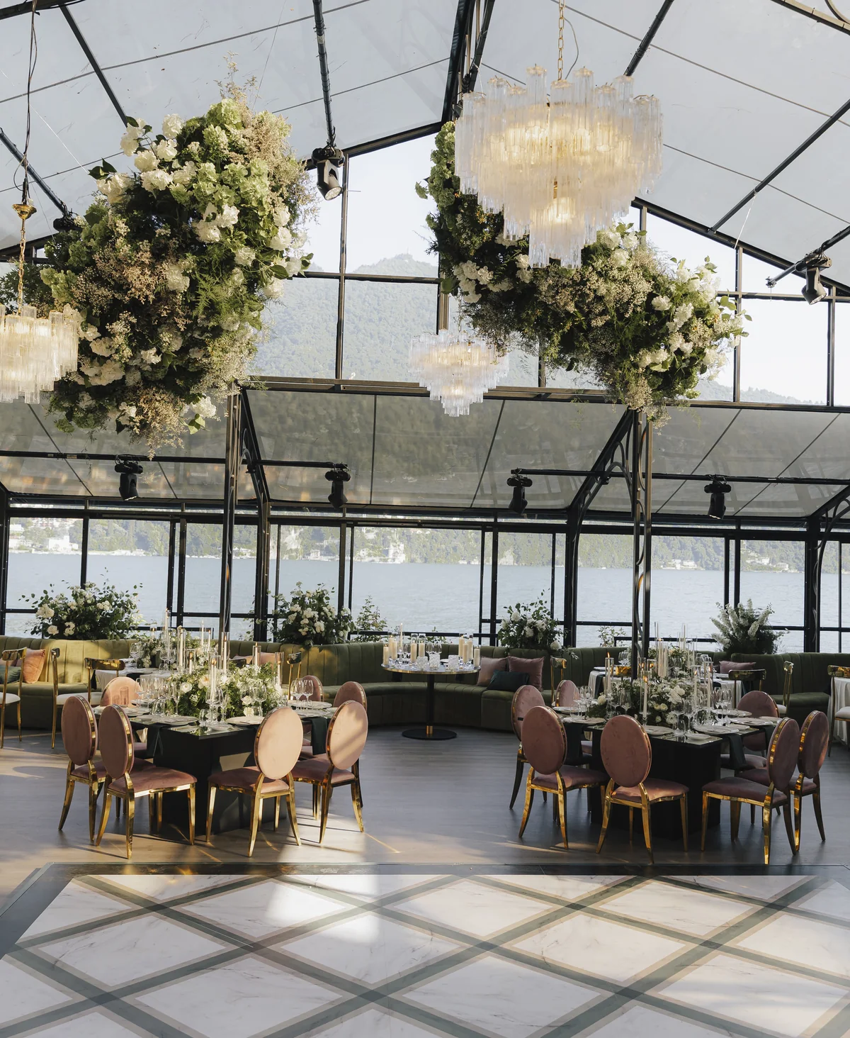 Glass reception pavilion at Villa Pizzo with flowers and chandeliers