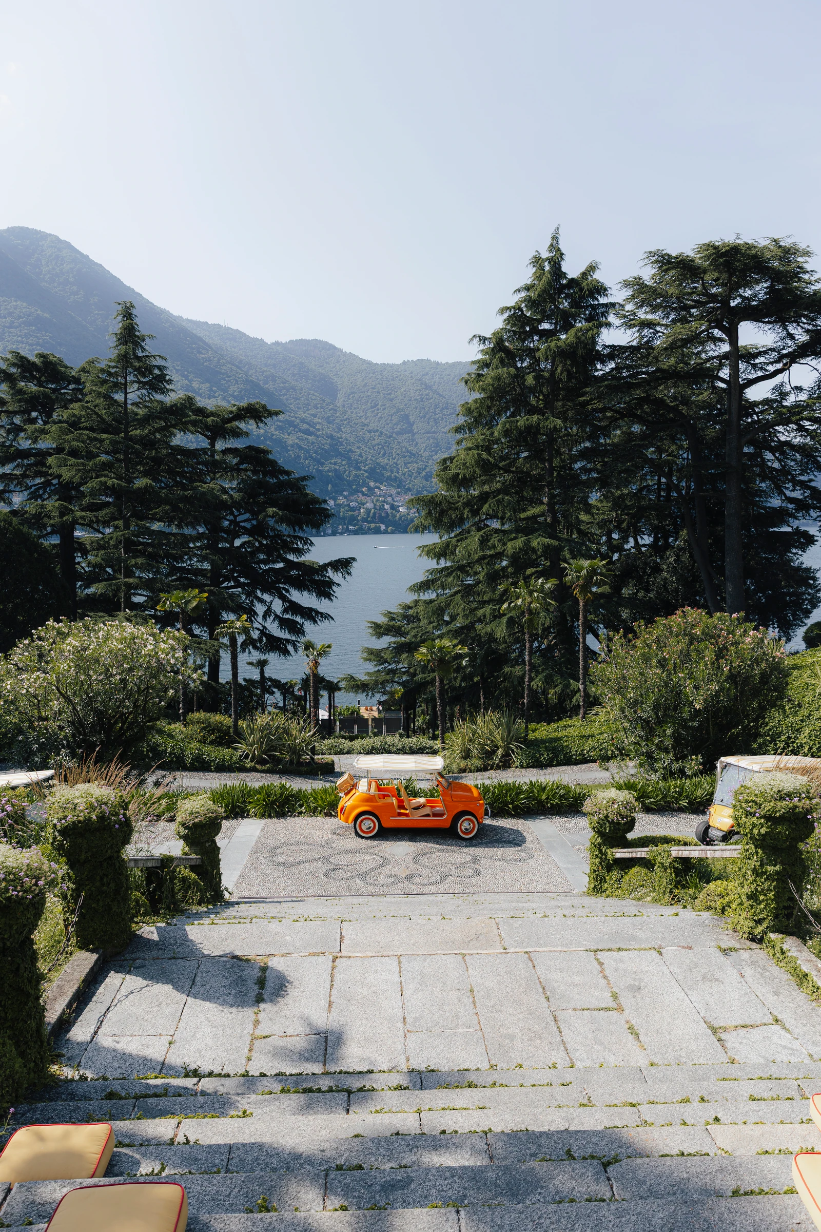 Orange open-top car below the garden steps at Passalacqua on Lake Como.
