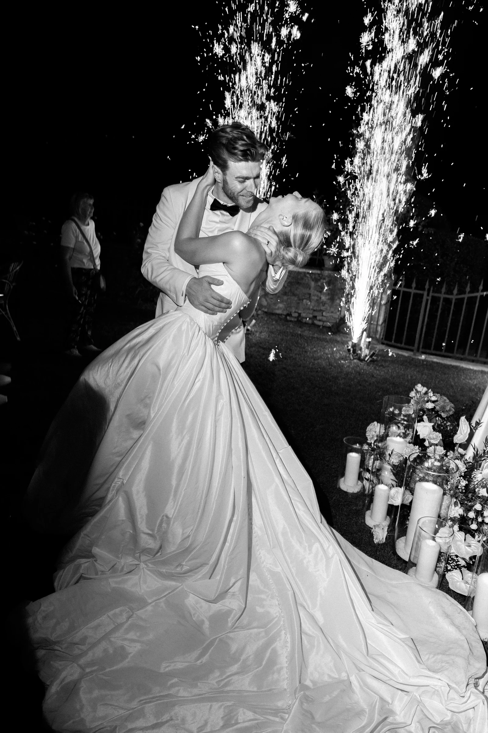Newlyweds kissing beneath sparkling fountains at Villa Arvedi near Verona.
