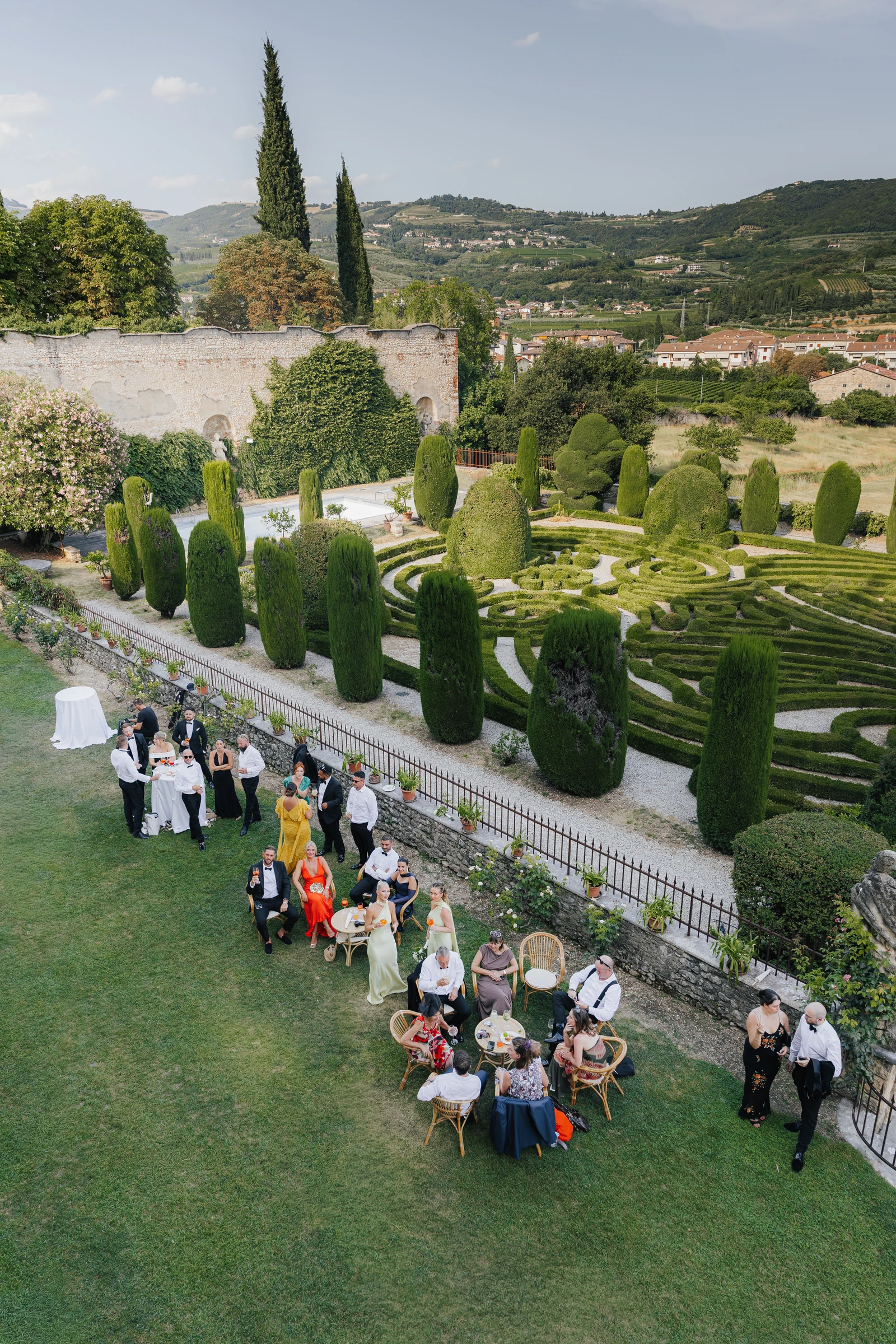 Wedding guests gathering beside the formal gardens at Villa Arvedi near Verona.