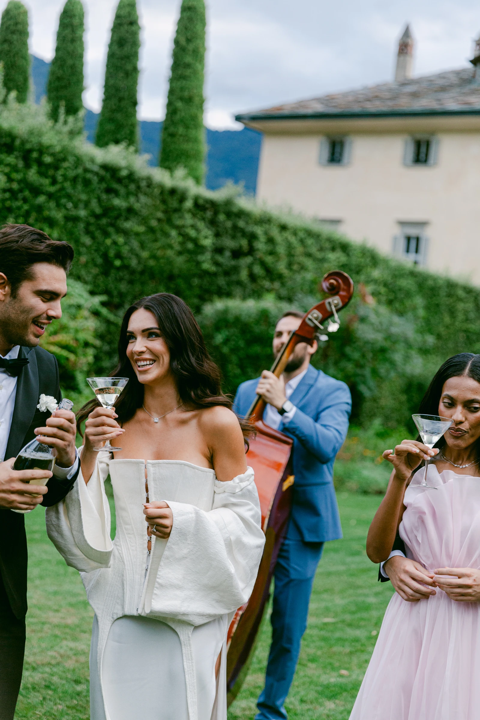 Bride and guests enjoying drinks beside a live musician at Villa Balbiano.