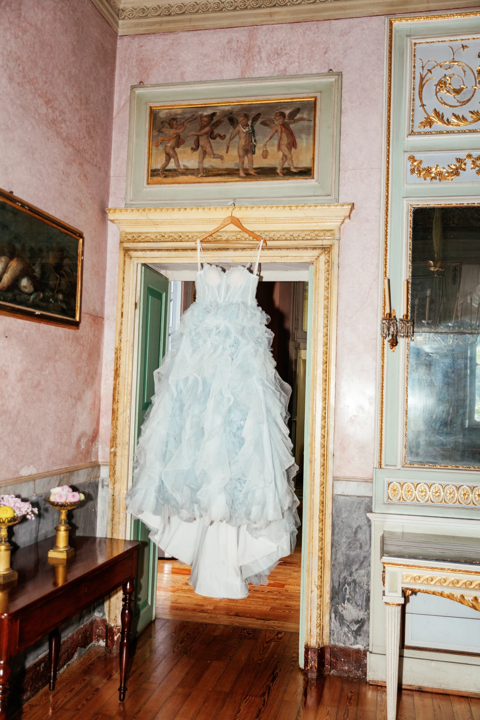 Pale blue wedding gown hanging in a gilded room at Villa Pizzo.