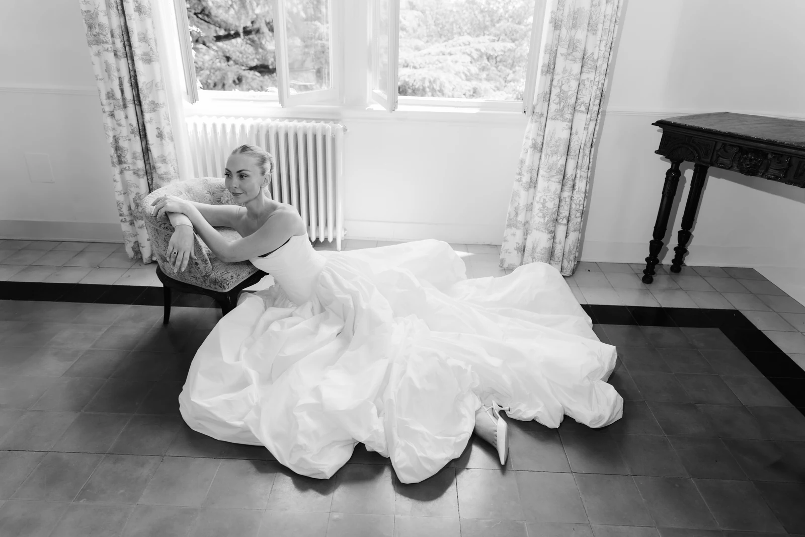 Bride sitting beside a window with her gown spread across the floor at Villa Pizzo.