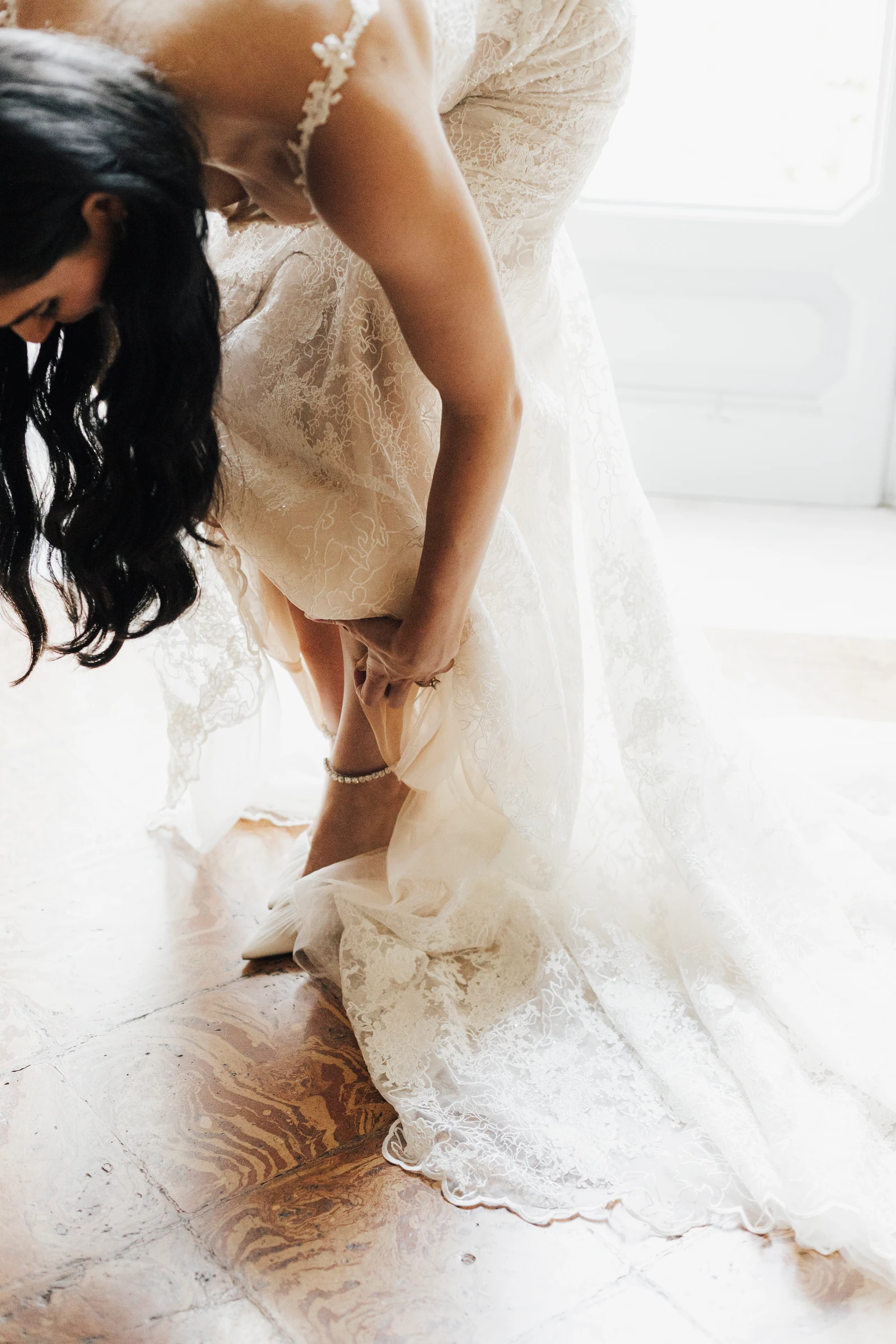 Bride leaning forward during wedding dress preparations at Villa Pizzo.