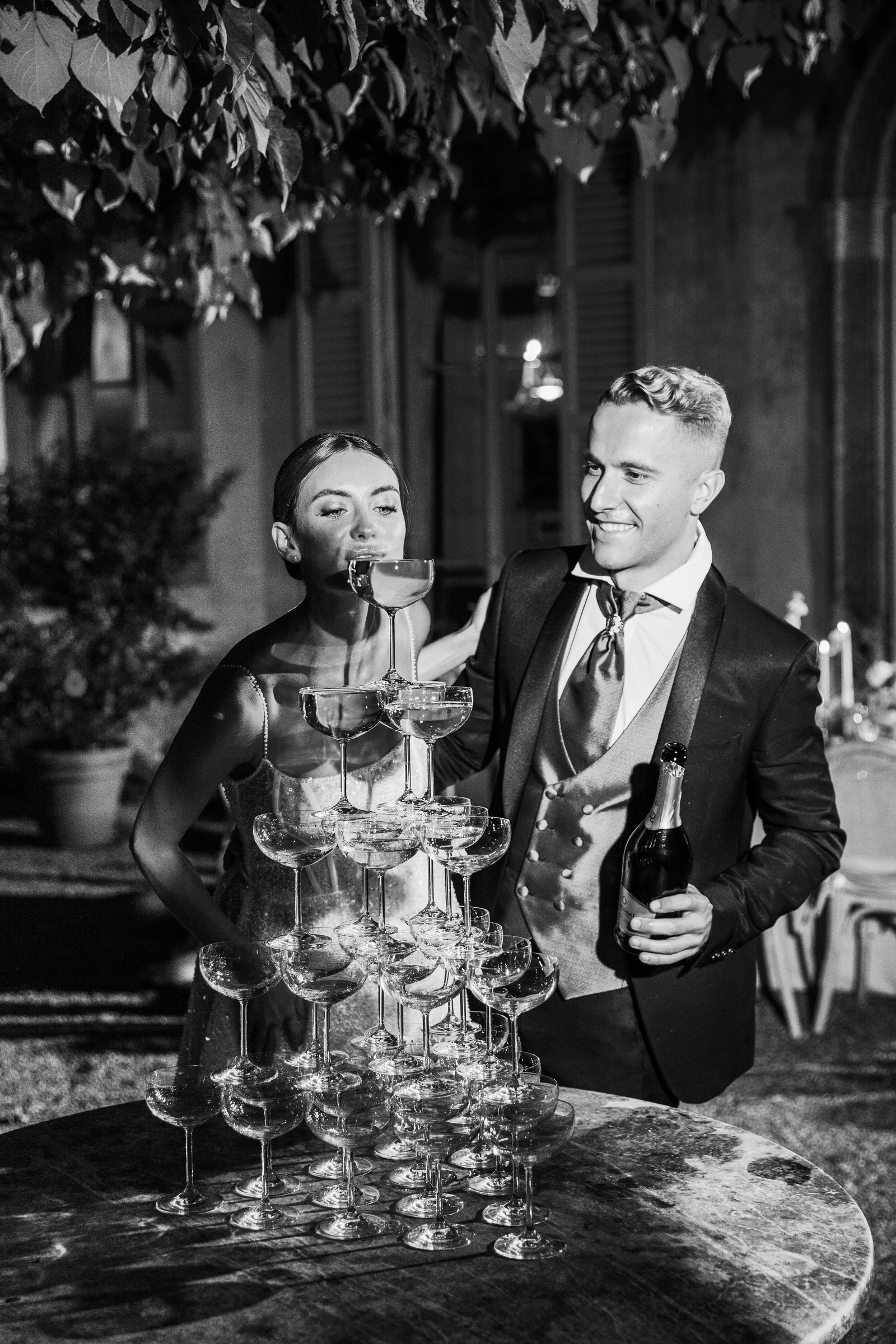 Couple celebrating beside a champagne tower at Villa Pizzo on Lake Como.
