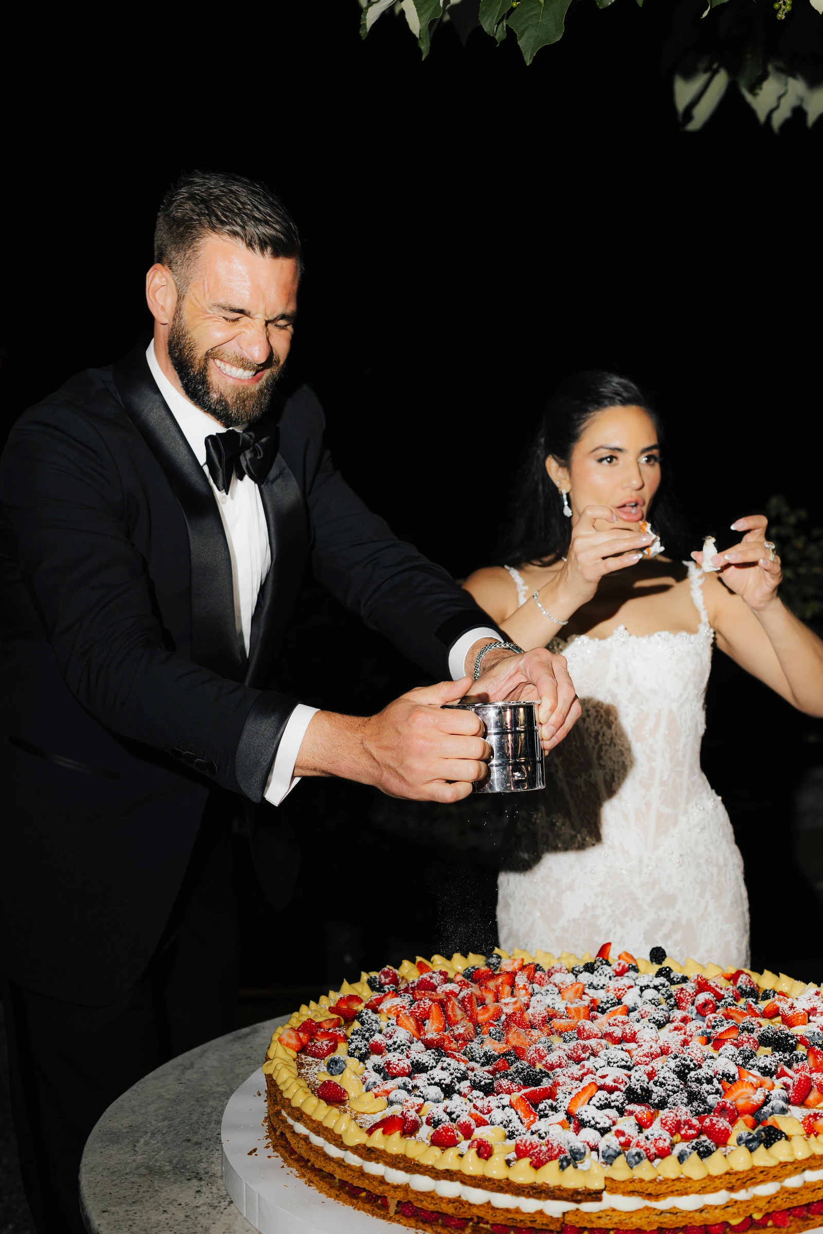 Couple sharing a moment beside their fruit-tart wedding cake at Villa Pizzo.