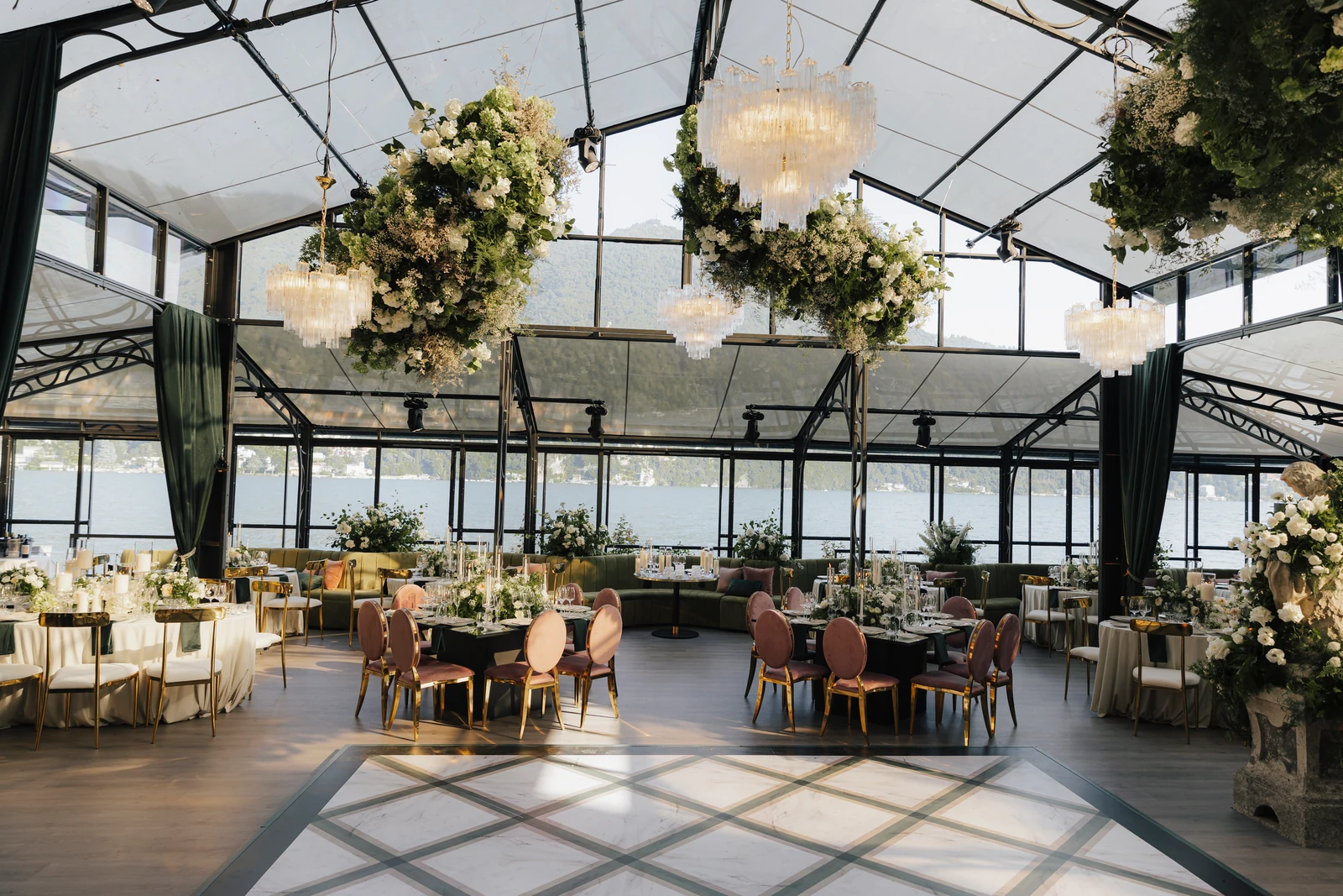 Glasshouse at Villa Pizzo set for the wedding reception with flowers and chandeliers.