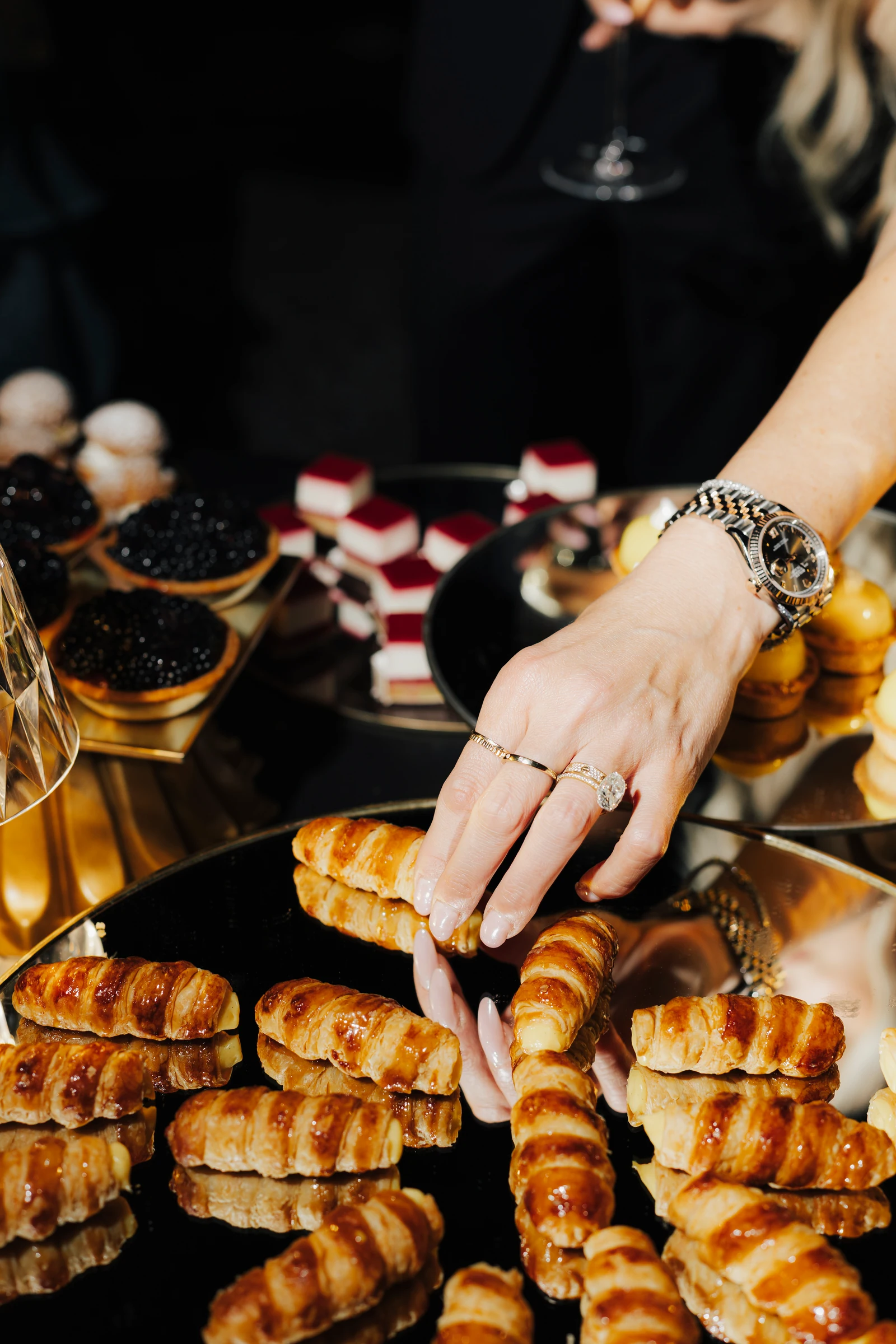 Hand reaching for a savoury pastry at the Villa Pizzo evening celebration.