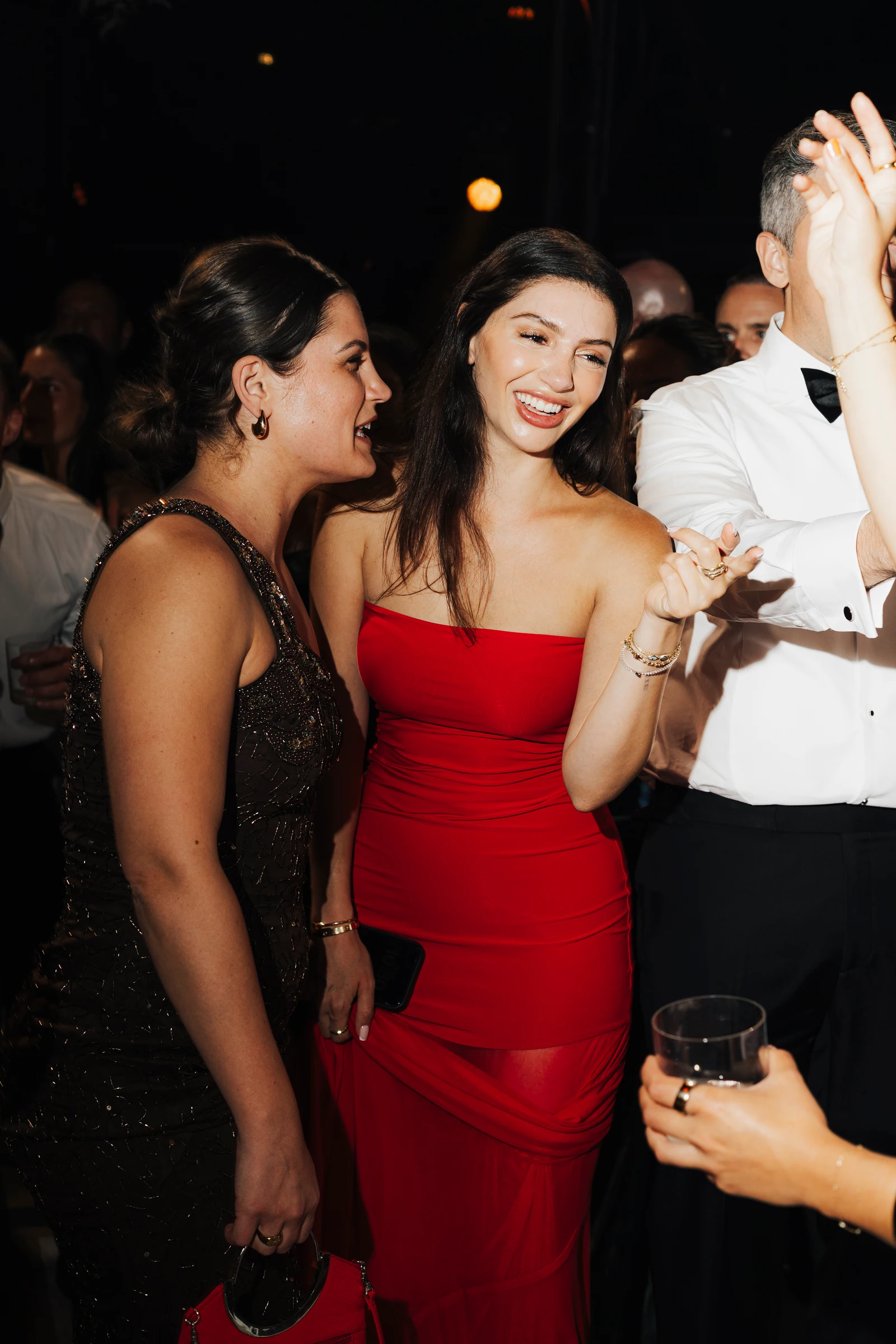 Guest in a red dress dancing with friends at the Villa Pizzo evening party.
