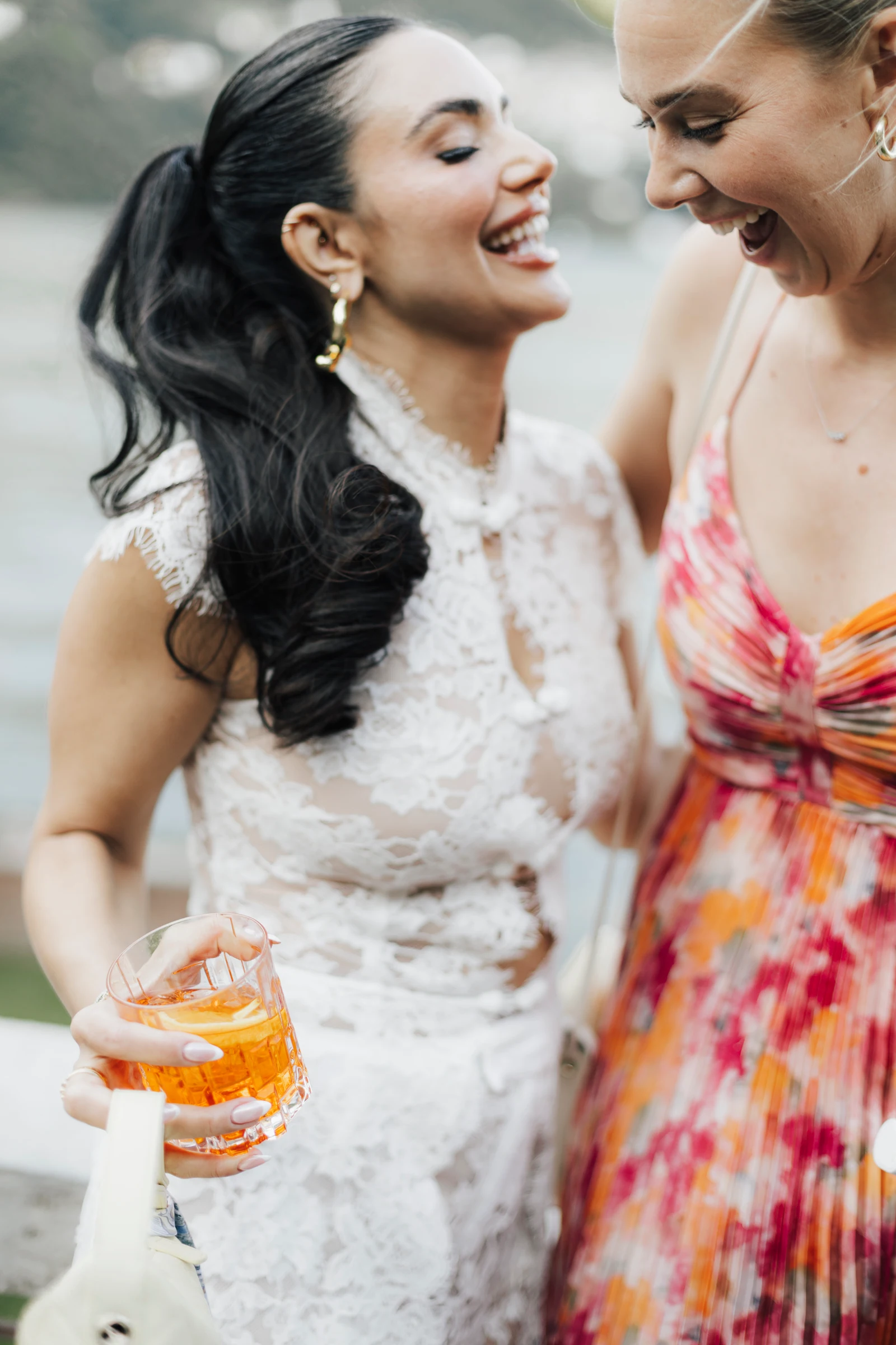 Bride and friend laughing over aperitivo at Villa Regina Teodolinda.