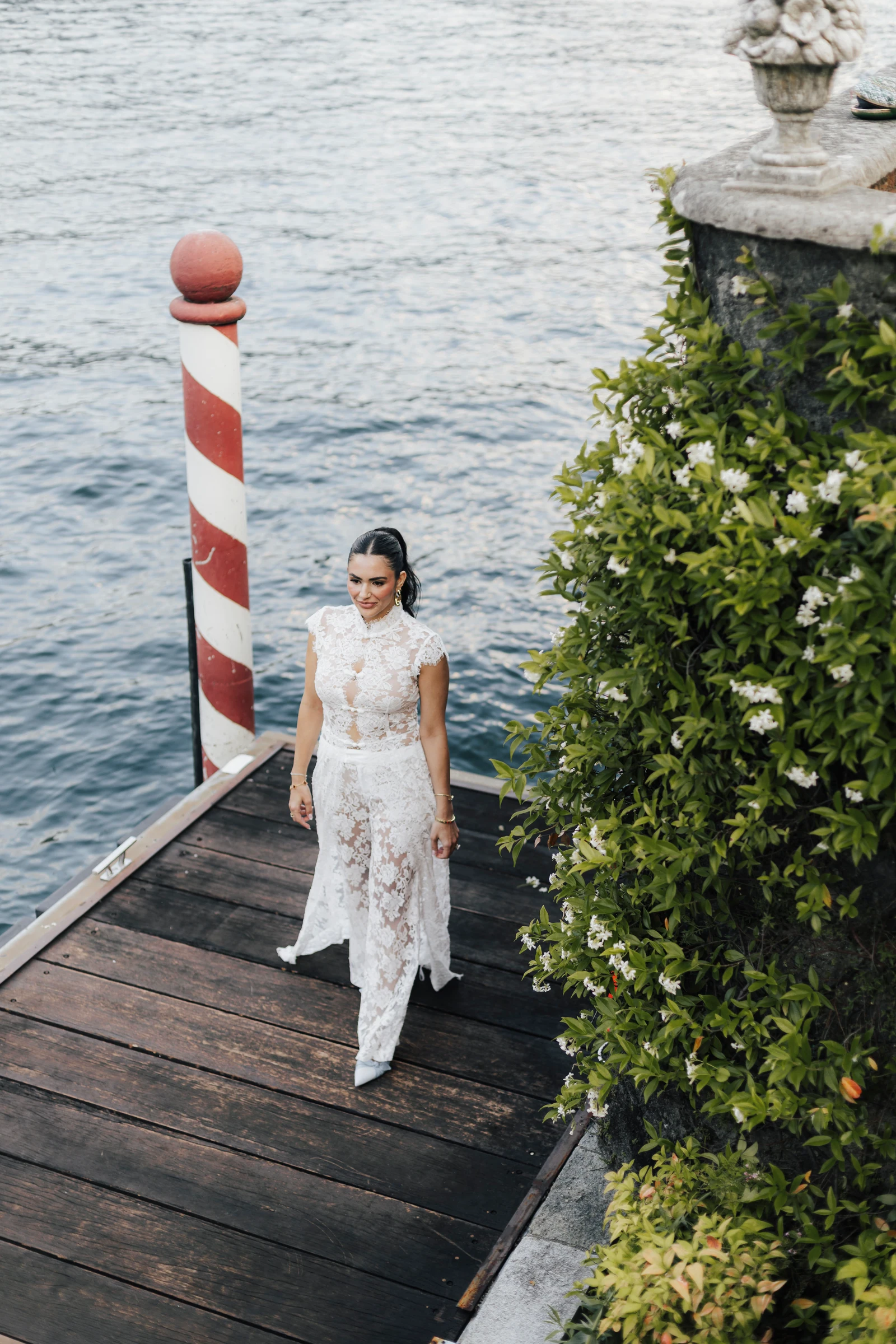 Bride walking along the wooden lakeside dock at Villa Regina Teodolinda.
